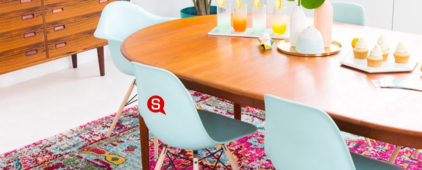 Wnętrze jadalni zaaranżowane w klimacie boho. Drewniany stół, kolorowe krzesła z tworzywa świetnie pasują do tego stylu.